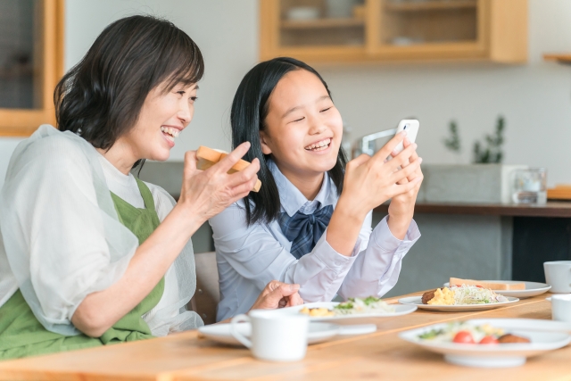 親子でスマホを見ている